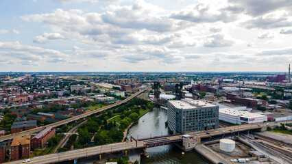 Obraz premium Chicago, IL USA-July 19th, 2022: aerial drone shot of a warehouse building by the Chicago river during sunset in the industrial district of Chinatown. cars drive over the bridge during rush hour