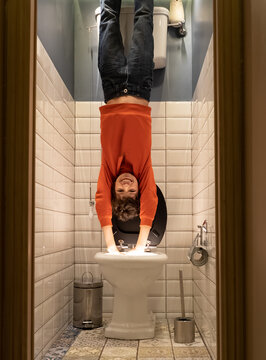 Boy playfully diving into the toilet. Fun and jokes concept.