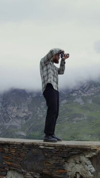 Russia, Caucasus. A man takes pictures of the mountains with a camera