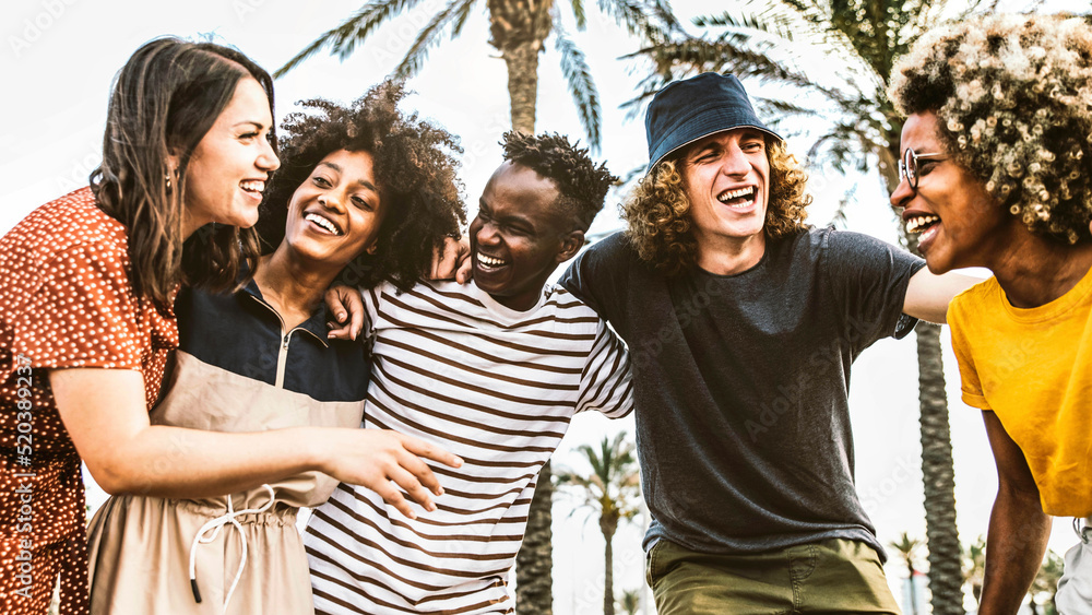 Wall mural multicultural friends having fun together outside - group of young people laughing out loud walking 