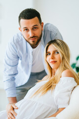 Fototapeta premium Future mother and father clasped pregnant big tummy. husband hugs pregnant wife. Happy family resting at home