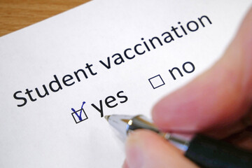 Hand daw in the questionnaire. A closeup of female hand answering about a student vaccination...