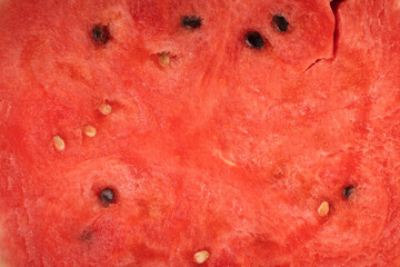 Close up shot of ripe slice of watermelon as a background texture. Hot summertime concept. Macro background of juicy red berry