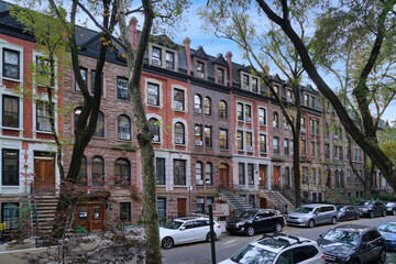 Residential street in New York with long row of old brownstone townhouses