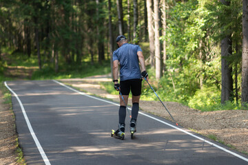Man ride roller skis in the autumn Park.