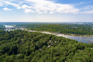 view of the river in the city nature aerial drone bridge water blue sky rocks luscious green trees virginia sunny day