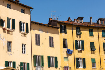 Fototapeta na wymiar Weathered House Facade At The Famous Piazza dell'Anfiteatro In Lucca