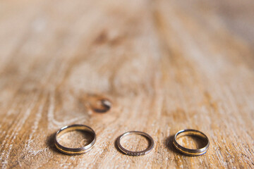 Three wedding rings on a wooden background