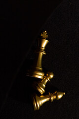Obraz na płótnie Canvas golden chess pieces lie on a black background top view
