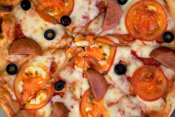 Fresh round pizza with tomatoes, sausage, mozzarella and olives. Tasty unhealthy takeaway food. - 520395649