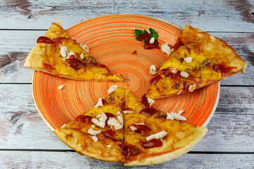 Half-eaten homemade pizza with cheese, chicken meat, olives, ketchup on plate. Tasty unhealthy fast food snack of Mediterranean food. - 520395689