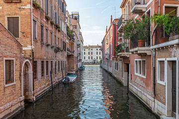 Fototapeta na wymiar Narrow canal with old colorful houses in Venice, Italy 