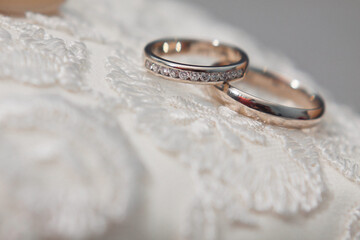 Obraz na płótnie Canvas Two rings lie on a wedding dress