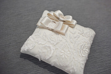Two wedding rings on a lace pillow