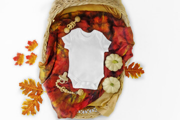 Mockup of white baby bodysuit shirt . Fall Pregnancy announcement background with blurred ....