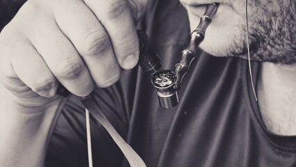 Smoking a Cannabis Pipe. A man with stubble lights a pipe with marijuana. Monochrome Photo