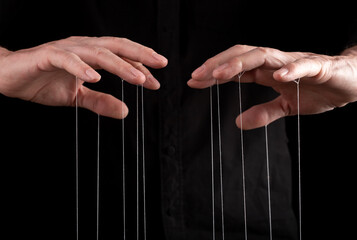 Hand manipulating and controlling smth with strings concept. High quality photo