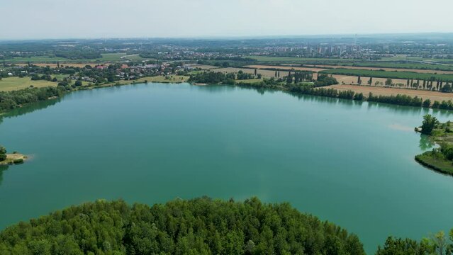Arial air view on afloat gravel pit named Male Kalisovo jezero lake neat Bohumin city during spring afternoon with blue sky and few clouds