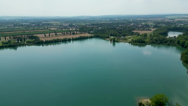 Arial air view on afloat gravel pit named Male Kalisovo jezero lake neat Bohumin city during spring afternoon with blue sky and few clouds