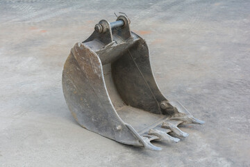 old dirty shabby excavator bucket lies on dirty asphalt