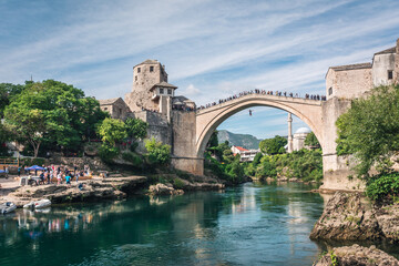 MOSTAR, BOSNIA AND HERZEGOVINA - September 22, 2021: Man is jumping diving from Stari most, Old...