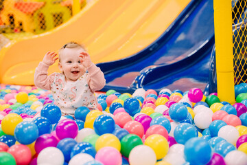 Obraz na płótnie Canvas small child playground slide lot colorful balls