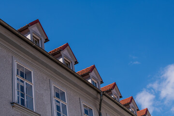 Hausfassade mit vielen Dachgauben, Altbau vor blauem Himmel