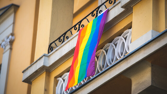 Rainbowflag hanging down from a balcony in the city, LGBT community, pride -diversity