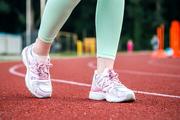 Close-up, female legs in sneakers at the stadium.