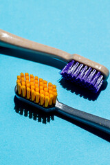 Two bright new toothbrushes on blue