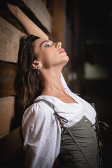 Fototapeta premium Young beautiful girl in the white dress posing in the horse stable.