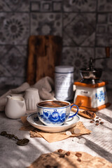 Morning still life on the kitchen table. A cup of freshly brewed coffee on the kitchen table. Gzhel painting. Blue and white coffee couple. A concept for good morning wishes.Photo coffee in vintage.
