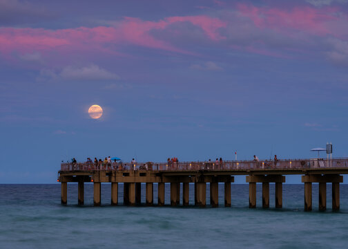 Full moon over Piers with people
