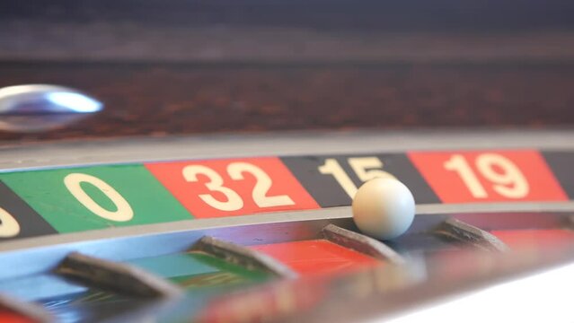 Ball on wooden french roulette table in casino. Wheel spinning, turning or rotating. Odd and even numbers, black, red and zero sectors. Bets in game of chance. Money playing, gambling or risky betting