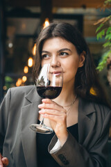 Attractive young woman with a glass of wine in a restaurant.