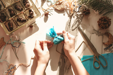 Teenage girl making handmade Christmas gift with chocolate sweets for New Year, Christmas holidays. Do it yourself concept, creativity, step by step process.