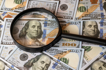 us dollars and magnifying glass