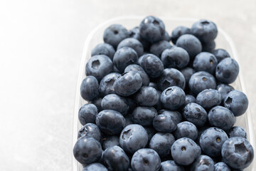 Fresh blueberries in a container on a white background.