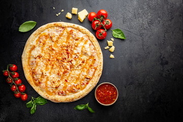 Tasty pizza with chicken and Sweet and sour sauce and cooking ingredients tomatoes and basil on...