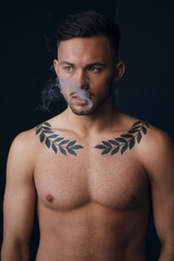 Fototapeta premium Modelling snapshots. Pensive serious tanned attractive handsome naked man thinking looks aside smoking posing isolated in black studio background. Fashion offer. Copy space for ad. Closeup