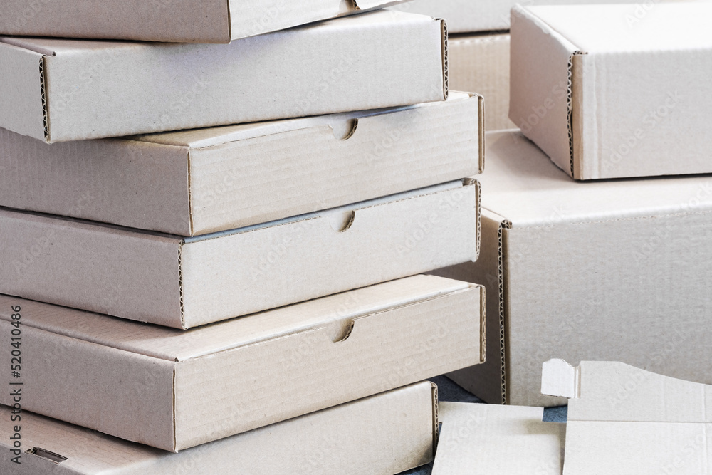 Poster Stack of empty cardboard boxes for packaging close-up