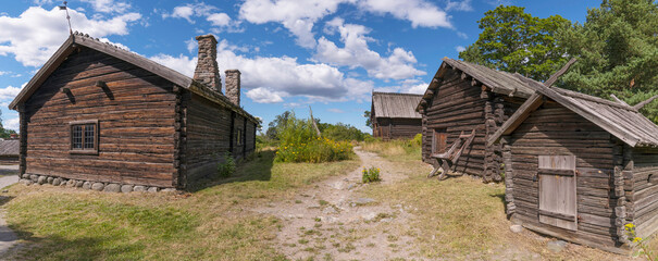 Old log farm houses in a meadow, a sunny summer day in Stockholm
