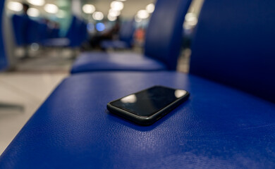 Close up view and low light. A smartphone is on seat in the room. Because people forget after...