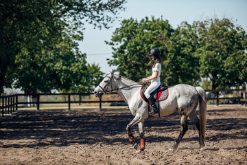 Teenage Girl in helmet Learning Horseback Riding.