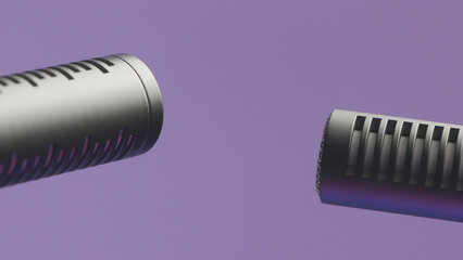 Fototapeta na wymiar Two microphone on isolated background. Action. Modern professional microphones for high-quality sound recording. Microphone cannon on purple background. Long microphone for singing