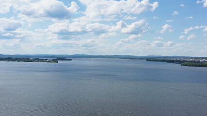 Fototapeta na wymiar Top view of beautiful lake on background of horizon with sky. Video. Panorama of clear lake and green shores with beautiful horizon of blue sky