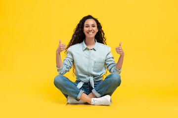 Lady Gesturing Thumbs Up With Both Hands On Yellow Background