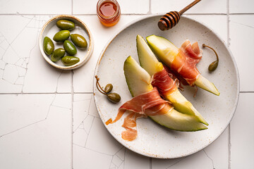 Jamon serrano, ham or prosciutto with melon and olives, a traditional Spanish and Italian appetizer...