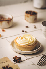 Mini tart with whipped cream and lemon, sweet dessert on white plate
