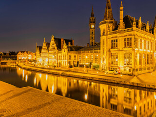 Fototapeta na wymiar Historic medieval building illuminated at night on Leie river in Ghent, Belgium